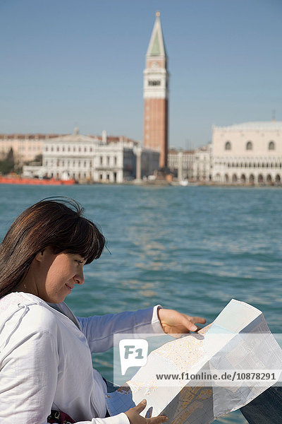 Junge Frau beim Kartenlesen am Hafen gegenüber dem Markusplatz  Venedig  Italien