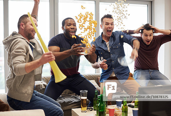 Group of men watching sport event on television celebrating