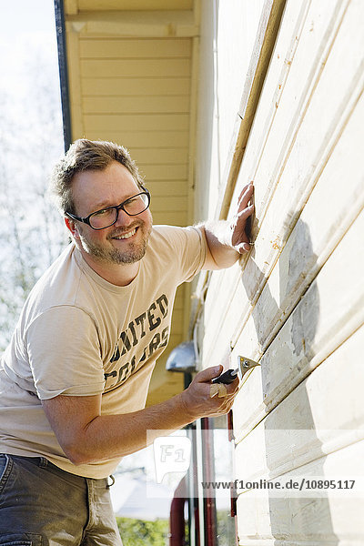 Schweden  Vastra Gotaland  Porträt des Hausbesitzers Reparatur der Hauswand