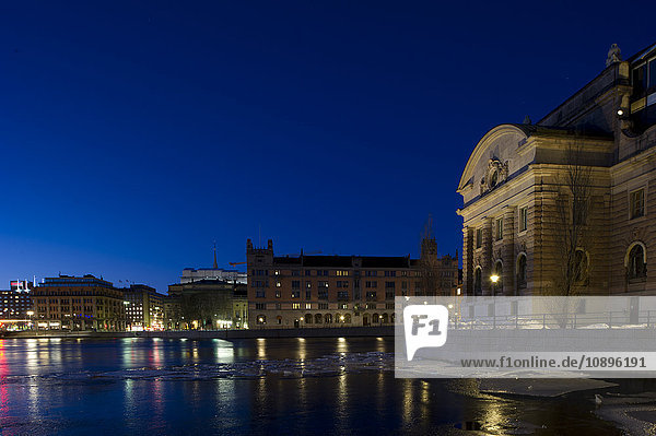 Stockholm Schweden Blick auf die Uferpromenade und das Parlamentsgebäude in der Abenddämmerung
