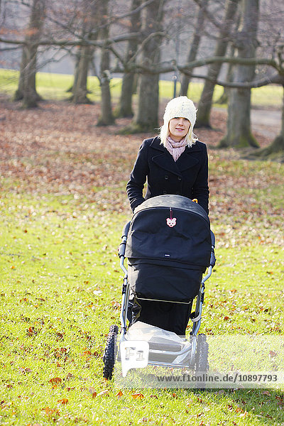 Schweden  Vastra Gotaland  Göteborg  Frau auf Spaziergang im Park mit Kinderwagen