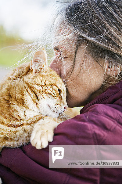 Schweden  Vastergotland  Fristad  Frau trägt und küsst Katze
