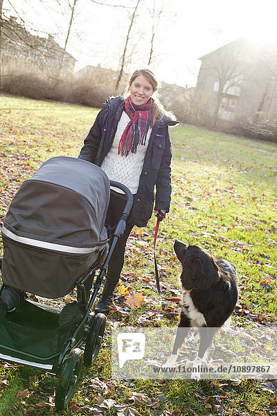 Schweden  Vastra Gotaland  Boras  Frau mit Kinderwagen und Hund an der Leine