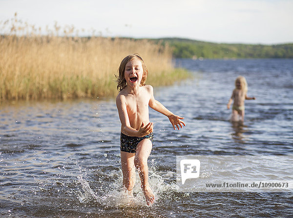 Sweden Vastergotland Lerum Lake Aspen Boy (8-9) and girl (6-7) playing in lake