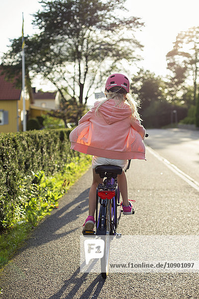 Schweden Vastergotland Lerum Girl (10-11) mit rosa Helm auf dem Fahrrad entlang der Straße