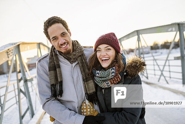 Schweden, Vasterbotten, Umea, Junges Paar auf Fußgängerbrücke im Winter