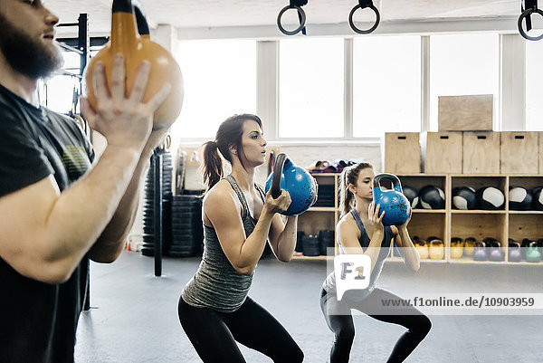 Deutschland Junge Frauen und Männer Crosstraining mit Kettlebells im Fitnessstudio