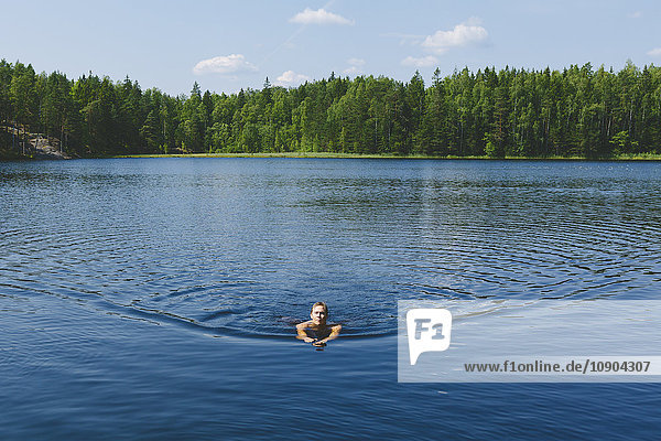 Finnland Uusimaa Espoo Kvarntrask-See Junger Mann im See schwimmend