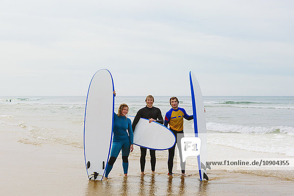 Portugal Lissabon Drei Personen mit Surfbrettern am Strand