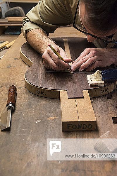 Luthier manufacturing a Spanish guitar in his workshop