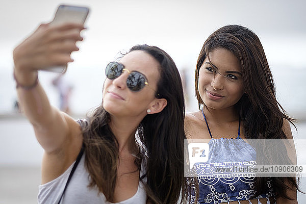 Two young women taking a smartphone selfie