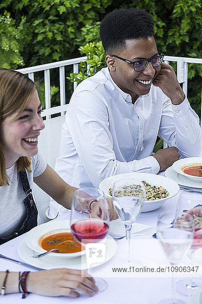 Young man and woman smiling during a summer dinner