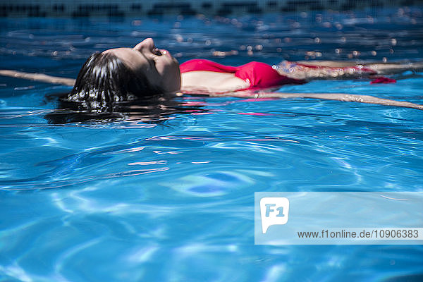 Woman floating on water of a swimming pool