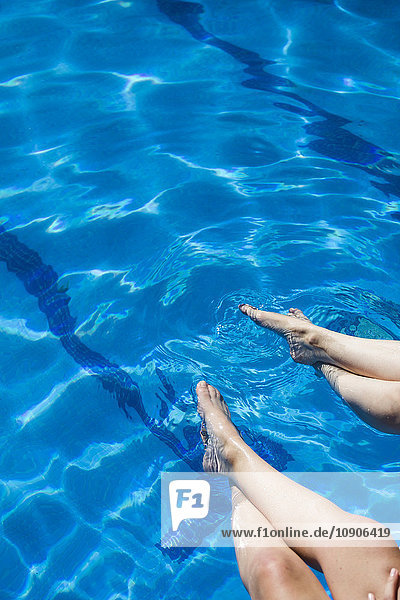 Beine von zwei Frauen im Wasser eines Pools