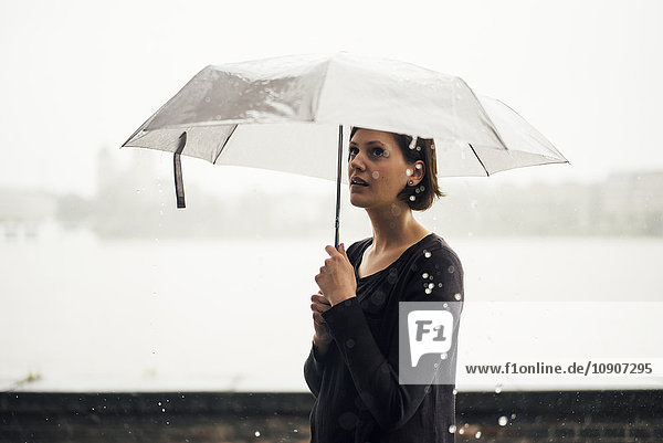 Frau mit Regenschirm an einem regnerischen Tag