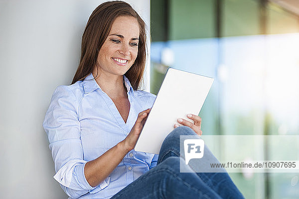 Smiling brunette woman using digital tablet