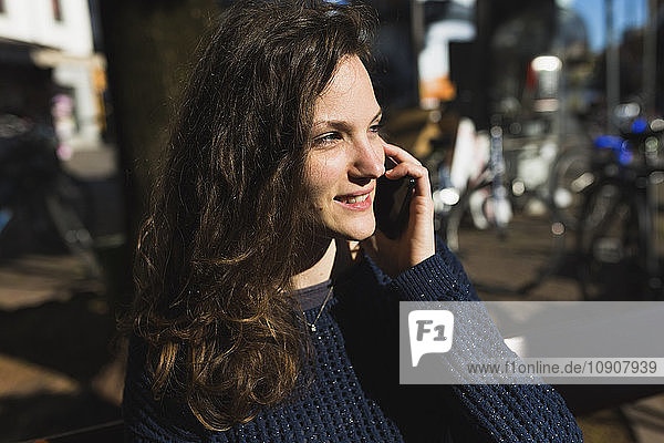 Portrait of smiling woman telephoning with smartphone