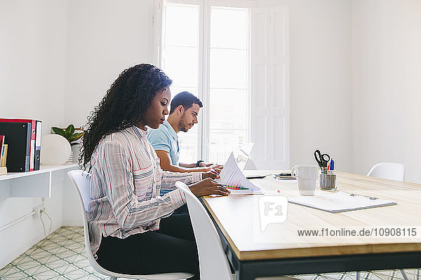 Young businessman and woman working together in office