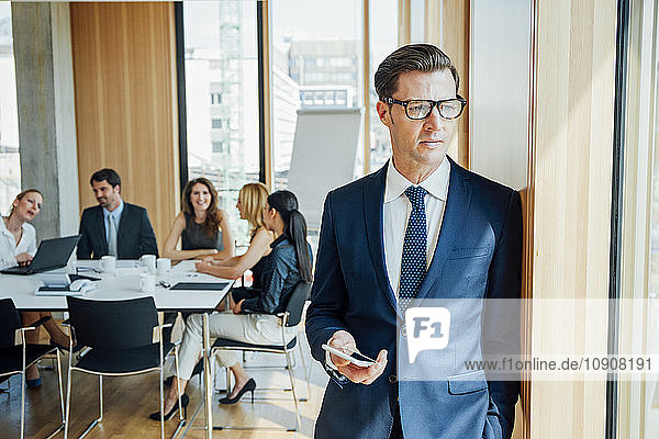 Thoughtful businessman with meeting in background