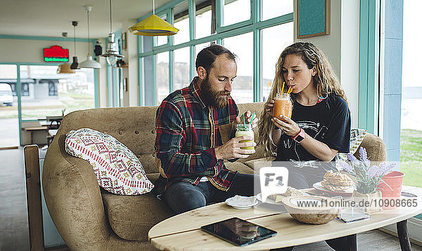 Couple having breakfast in cafe  drinking organic juices
