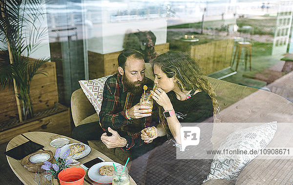 Couple having breakfast in cafe  drinking organic juices