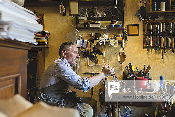 Cobbler making shoes in his workshop