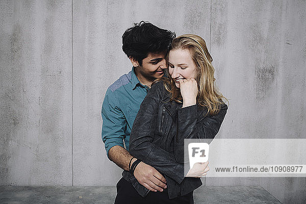 Young couple in front of concrete wall