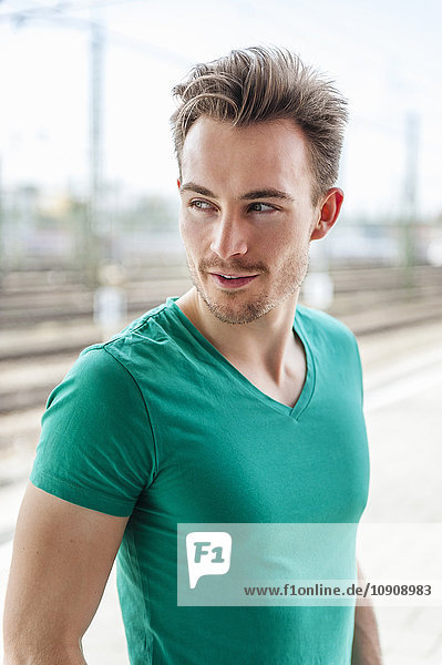 Portrait of smiling young man with stubble standing on platform