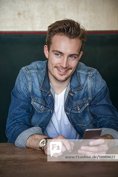 Portrait of happy young man sitting in a coffee shop