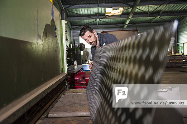 Man working  cutting machine  metal plate  in workshop