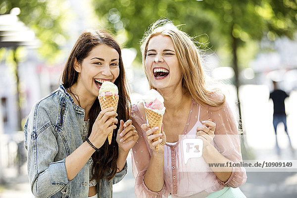 Zwei lachende junge Frauen mit Eistüten