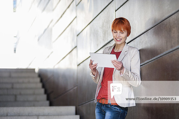 Lächelnde junge Frau mit digitalem Tablett
