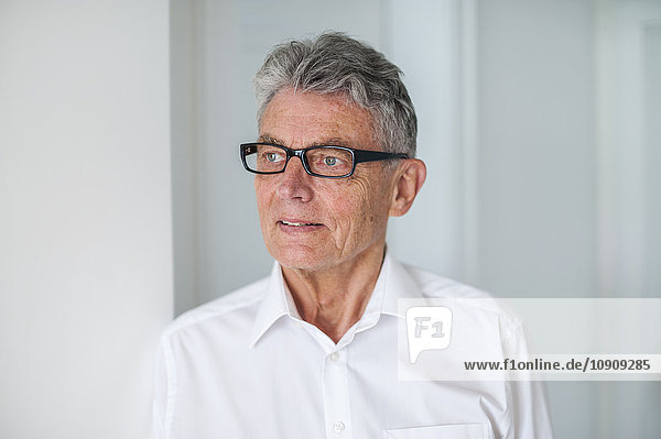 Senior man wearing glasses and white shirt