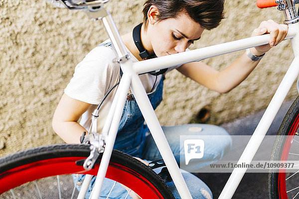 Junge Frau auf dem Fahrrad kauernd