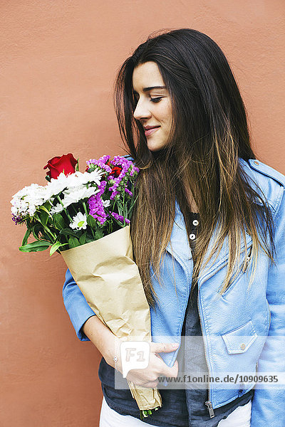Lächelnde junge Frau mit Blumenstrauß