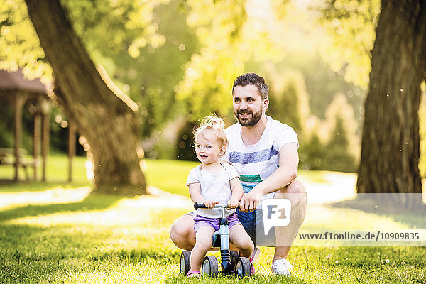 Vater und seine kleine Tochter mit Spielzeugauto im Park