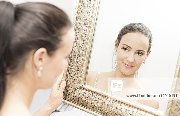 Lächelnde Braut schaut in den Spiegel