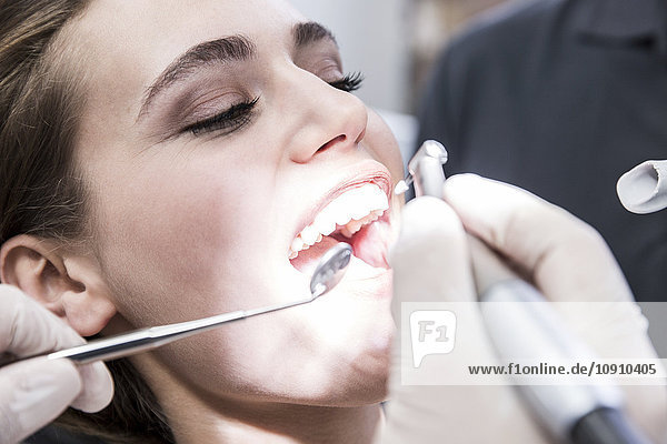 Junge Frau beim behandelnden Zahnarzt