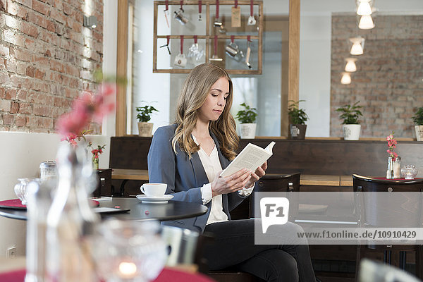 Junge Frau beim Lesen im Café