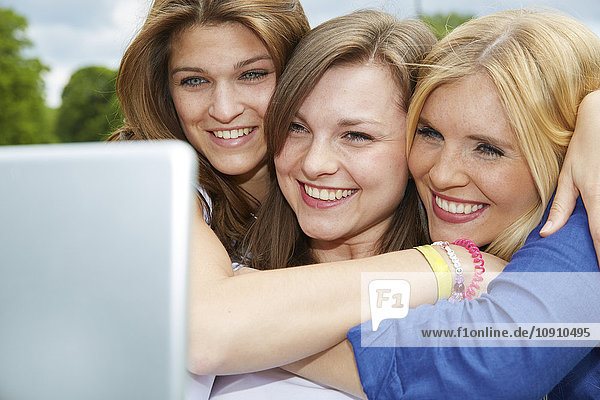 Drei lächelnde Freunde nehmen Selfie mit Tablette