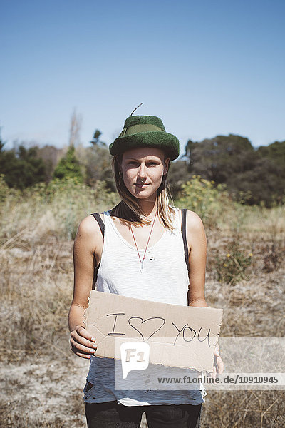 Hippie-Holding'Ich liebe dich' Schild in der Natur