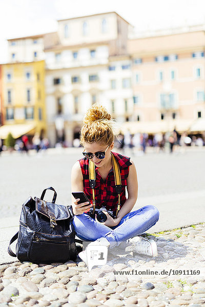 Italien  Verona  Frau auf dem Marktplatz beim Blick aufs Handy