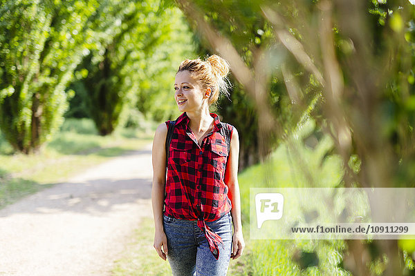 Lächelnde Frau beim Spazierengehen in der Natur