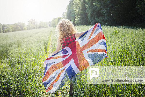 Rückansicht der Frau mit Union Jack in der Natur