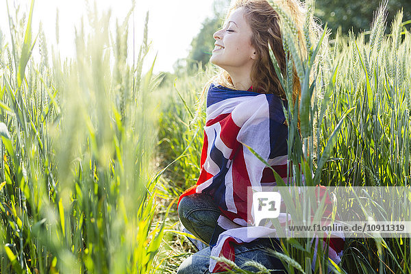 Lächelnde Frau mit Union Jack in der Natur