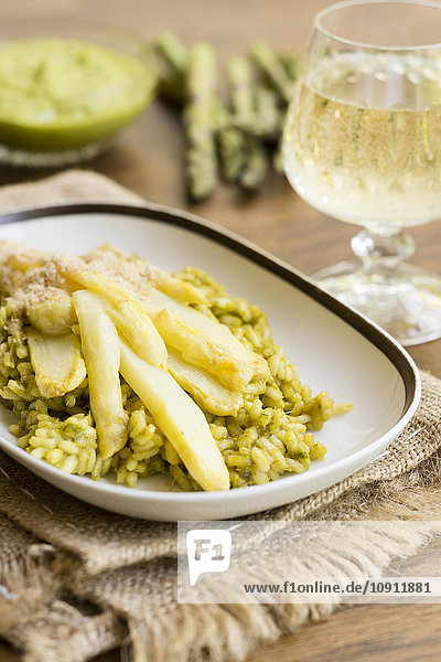 Risotto mit grünem Spargelpesto  weißen Spargelstangen und veganem Mandelparmesan