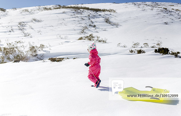 Spanien  Asturien  Mädchen mit Schlitten im Schnee