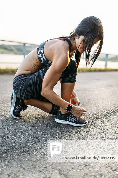Woman tying laces of sports shoes