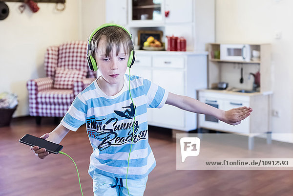 Junge mit Handy und Kopfhörern beim Tanzen