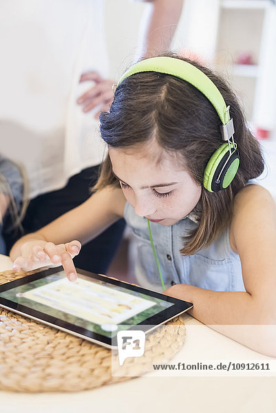 Mädchen mit Kopfhörer mit digitalem Tablett